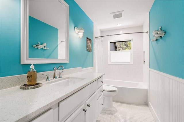 full bathroom featuring visible vents, toilet, wainscoting, vanity, and tile patterned floors