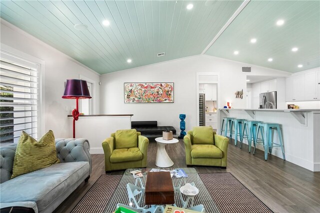 living area with recessed lighting, visible vents, vaulted ceiling, and wood finished floors