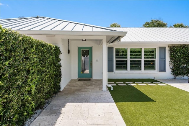 view of exterior entry featuring a yard