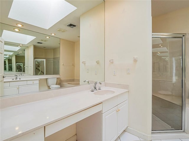 bathroom featuring vanity, a skylight, tile patterned floors, and walk in shower