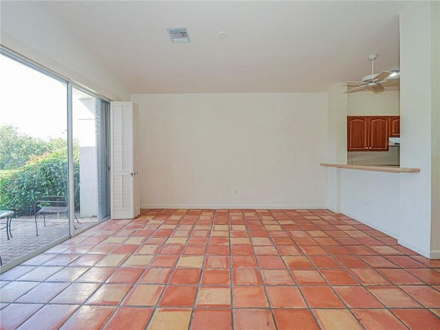 tiled spare room featuring ceiling fan