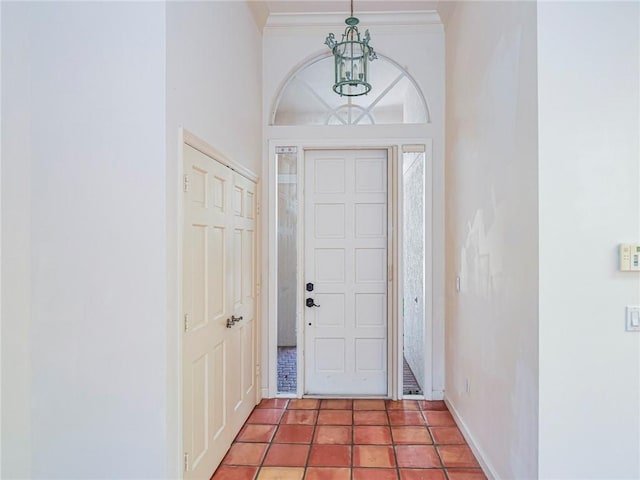 foyer entrance featuring crown molding and an inviting chandelier