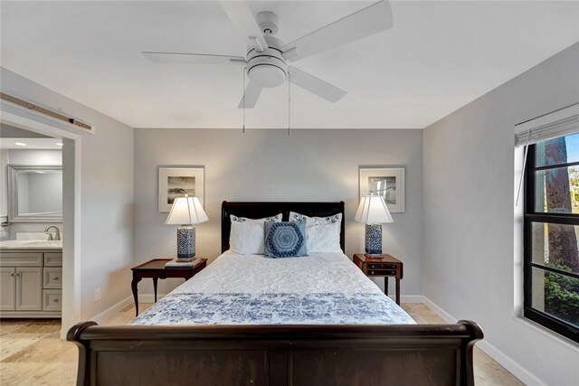 bedroom featuring ceiling fan, sink, and ensuite bath