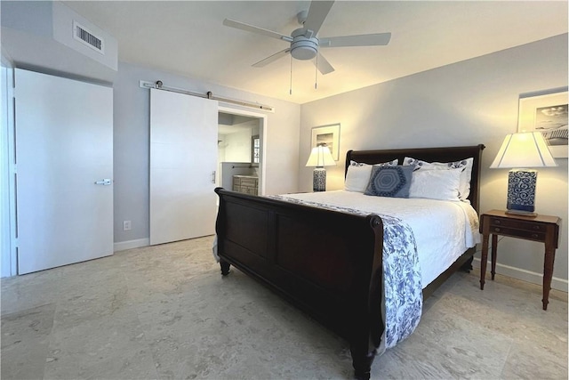 bedroom with a barn door, ceiling fan, and ensuite bath