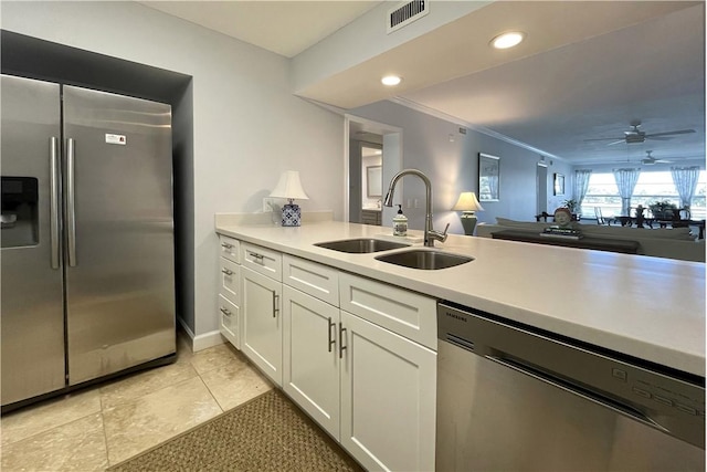 33 Plantation Dr Unit 104, Vero Beach, FL 32966 - kitchen with stainless steel appliances, white cabinetry, light countertops, ceiling fan, and crown molding