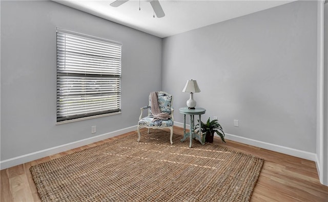 sitting room with hardwood / wood-style flooring and ceiling fan