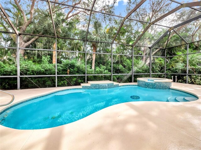 view of pool with a lanai and an in ground hot tub