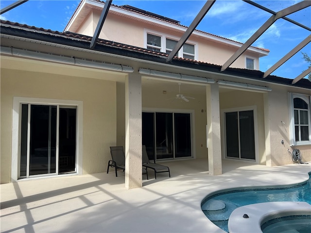 rear view of property featuring a lanai, ceiling fan, and a patio