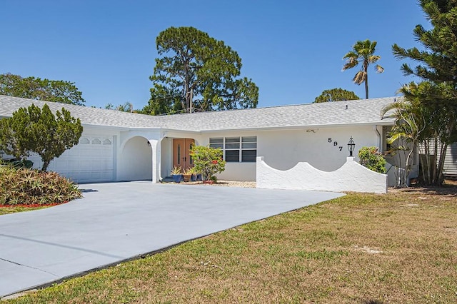 ranch-style house featuring a garage and a front lawn