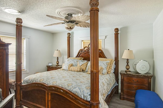 bedroom featuring hardwood / wood-style flooring, ceiling fan, and a textured ceiling