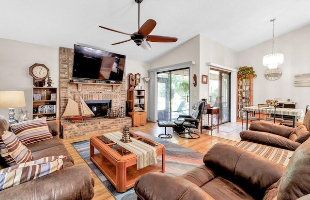 132 Keystone Dr, Sebastian, FL 32958 - living area featuring a ceiling fan, a chandelier, a brick fireplace, light wood-type flooring, and high vaulted ceiling