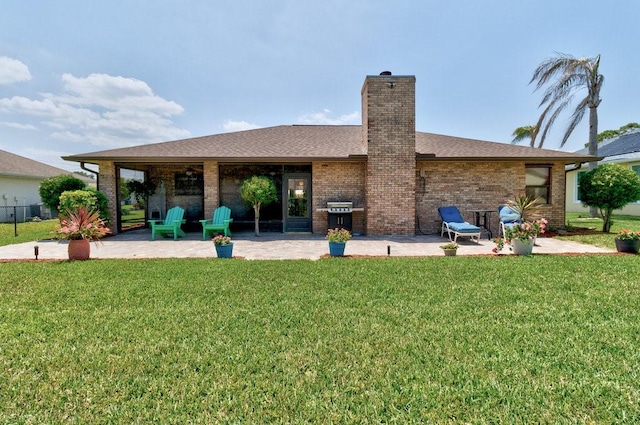 132 Keystone Dr, Sebastian, FL 32958 - back of house featuring a patio area, a lawn, brick siding, and a chimney