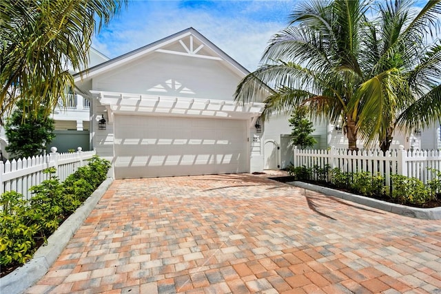 20 Strand Dr, Vero Beach, FL 32963 - view of front of home featuring an attached garage, fence, and decorative driveway