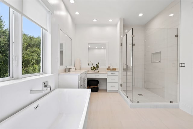 bathroom with vanity, a wealth of natural light, and independent shower and bath