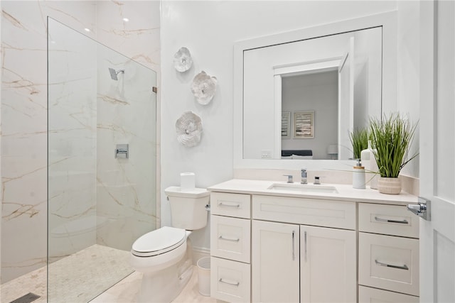 bathroom featuring tiled shower, vanity, and toilet