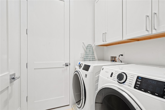 laundry room featuring cabinets and washing machine and clothes dryer