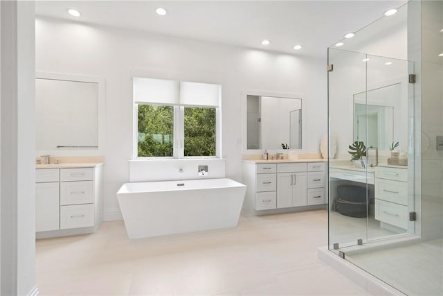 20 Strand Dr, Vero Beach, FL 32963 - bathroom featuring a stall shower, two vanities, a freestanding bath, and recessed lighting