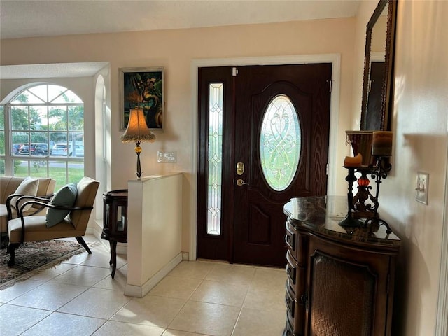 foyer featuring baseboards and light tile patterned flooring