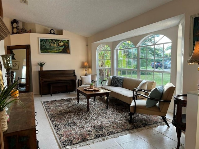 tiled living area featuring a fireplace, visible vents, vaulted ceiling, and a textured ceiling