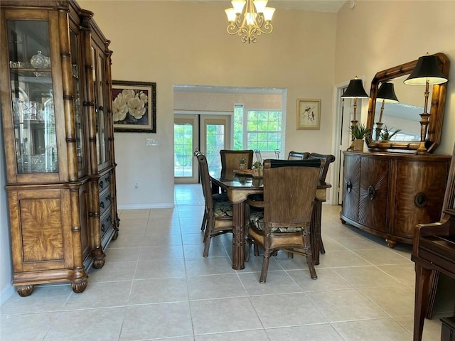 dining area featuring light tile patterned floors, baseboards, an inviting chandelier, a high ceiling, and french doors