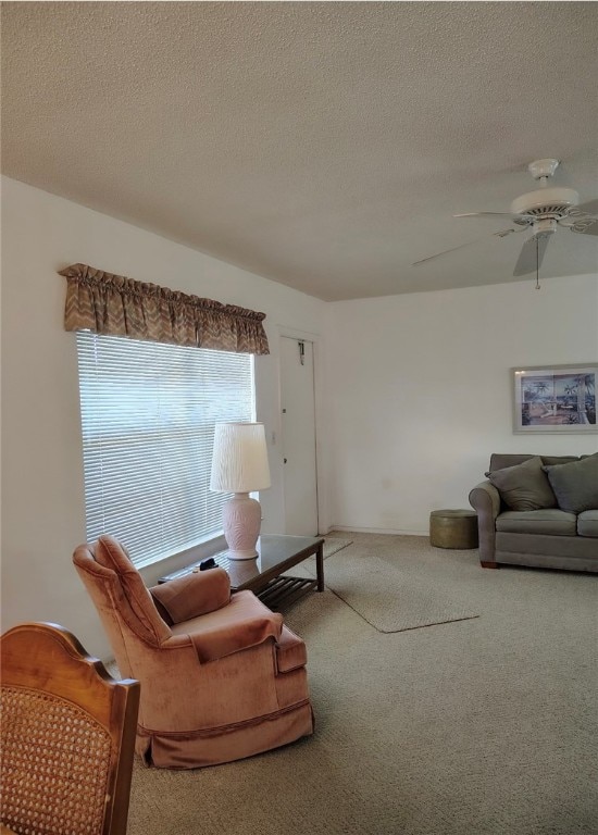 living room featuring carpet, a textured ceiling, and ceiling fan