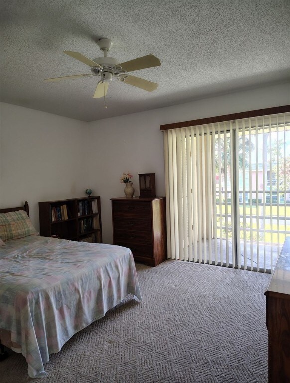 carpeted bedroom featuring ceiling fan, a textured ceiling, and access to outside