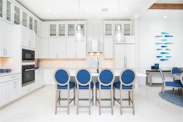 95 Strand Dr, Vero Beach, FL 32963 - kitchen featuring black appliances, wall chimney range hood, a breakfast bar area, decorative backsplash, and light countertops