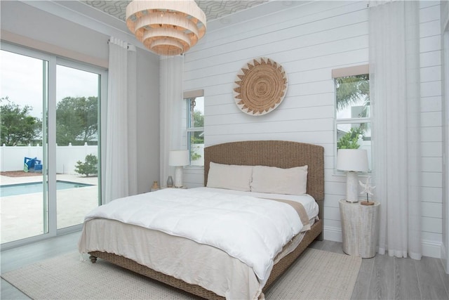 95 Strand Dr, Vero Beach, FL 32963 - bedroom featuring access to exterior, wood finished floors, and wood walls