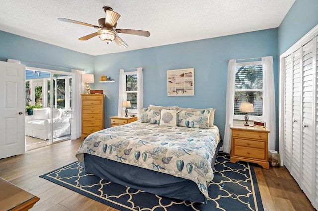 bedroom with ceiling fan, light hardwood / wood-style floors, access to outside, and a textured ceiling