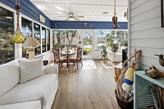 sunroom / solarium featuring ceiling fan and a water view