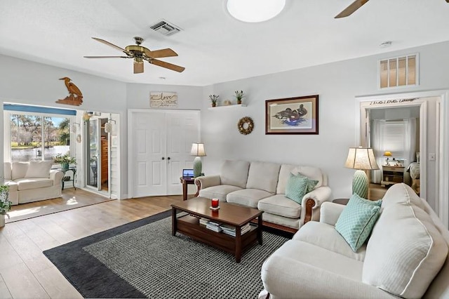 living room with ceiling fan and light hardwood / wood-style flooring