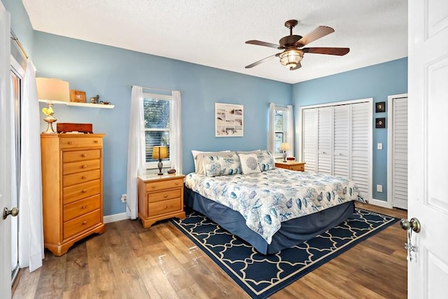 bedroom featuring multiple windows, ceiling fan, a textured ceiling, and hardwood / wood-style floors