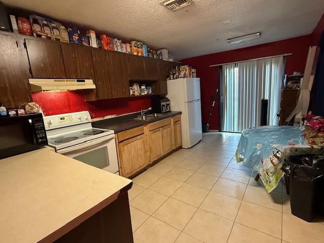 kitchen featuring sink, a textured ceiling, and white appliances