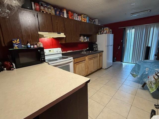 kitchen featuring sink, a textured ceiling, and white appliances