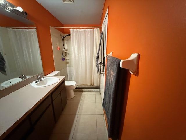 bathroom with vanity, walk in shower, tile patterned floors, and toilet