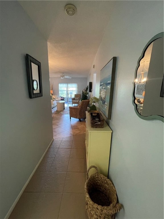 hallway featuring a textured ceiling and light tile patterned floors