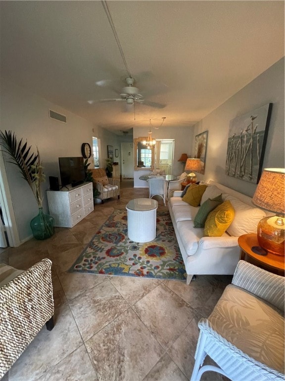 living room featuring ceiling fan with notable chandelier