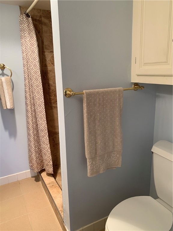 bathroom with toilet, a shower with shower curtain, and tile patterned floors