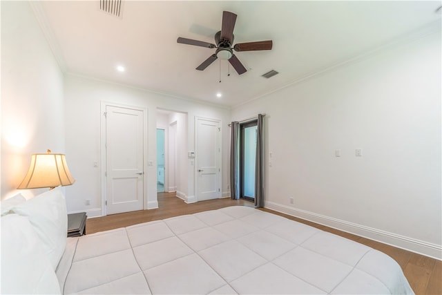 unfurnished bedroom with ceiling fan, light wood-type flooring, and crown molding