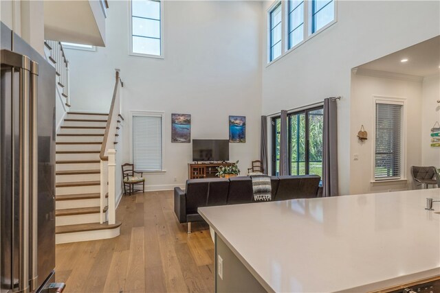 kitchen featuring a wealth of natural light, a high ceiling, high quality fridge, and light hardwood / wood-style flooring