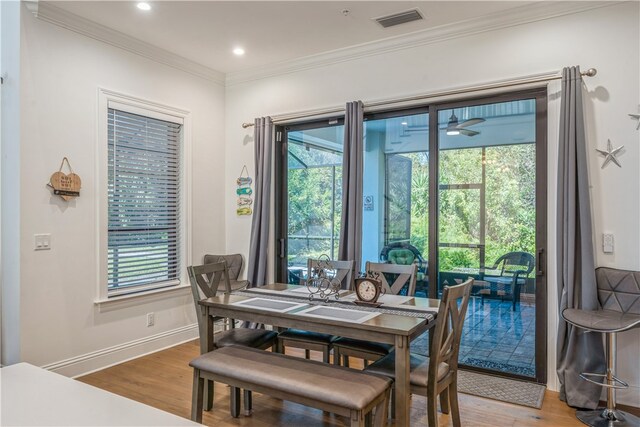 dining room featuring a wealth of natural light, hardwood / wood-style floors, ceiling fan, and crown molding