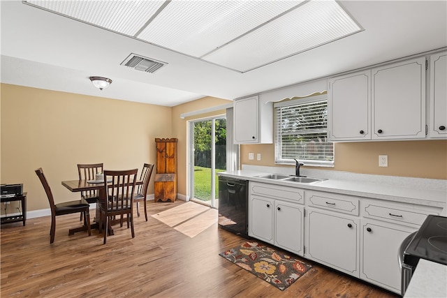 kitchen with hardwood / wood-style flooring, sink, range, white cabinets, and black dishwasher