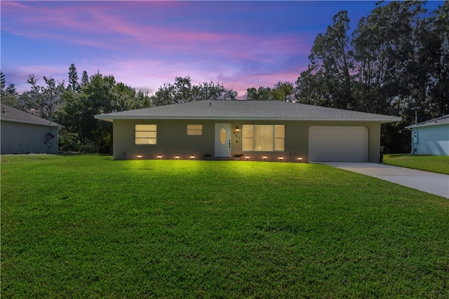 ranch-style home featuring a garage and a yard