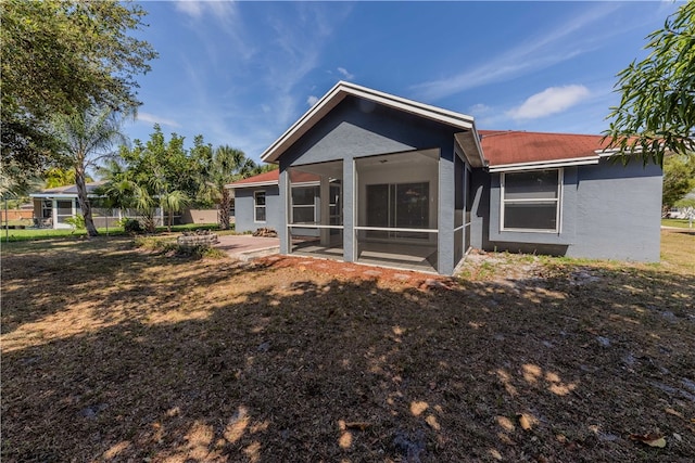 rear view of house featuring a sunroom