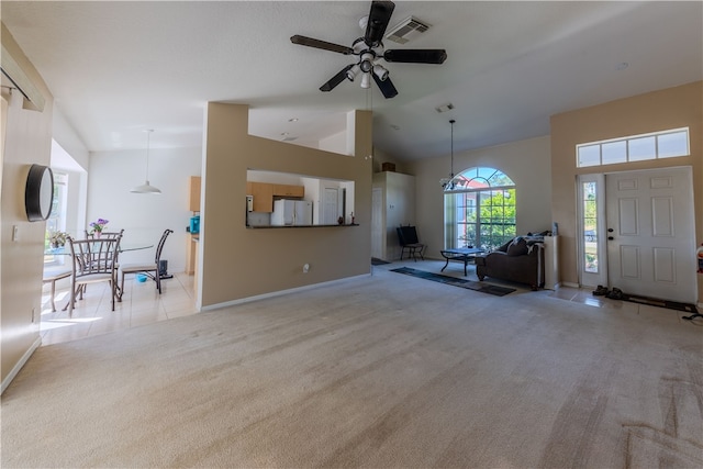 unfurnished living room with high vaulted ceiling, light colored carpet, and ceiling fan