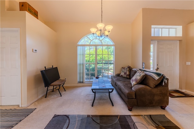 living room featuring a towering ceiling, light carpet, and an inviting chandelier