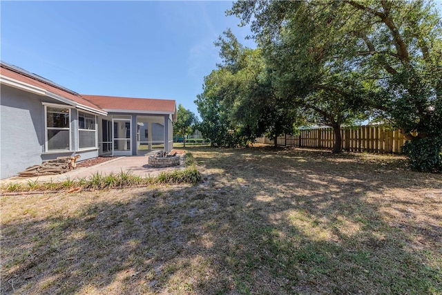 view of yard with an outdoor fire pit, a sunroom, and a patio area