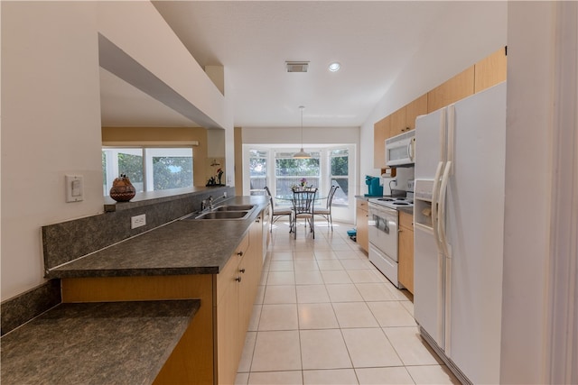 kitchen with lofted ceiling, hanging light fixtures, light tile patterned floors, sink, and white appliances