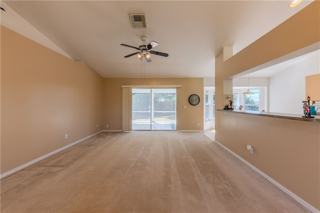 unfurnished room featuring ceiling fan, plenty of natural light, and light carpet