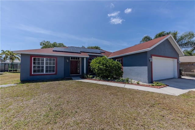 ranch-style house featuring a garage, solar panels, and a front lawn